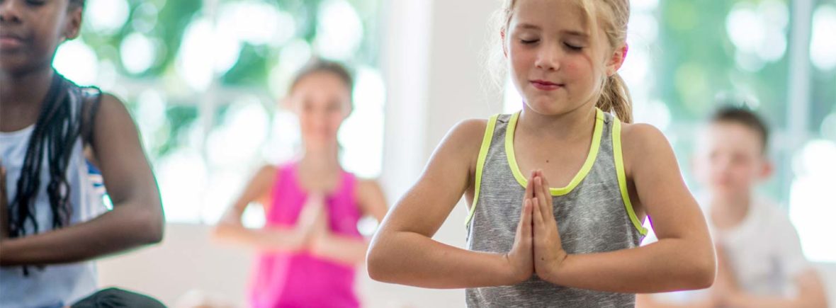 groupe d'enfants faisant du yoga en parascolaire